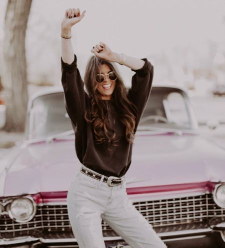 Madison Prewett  in a black t-shirt poses in front of her car at Colorado.
